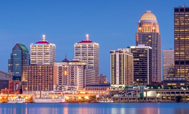 looking across the river just after sunset at the Louisville, Kentucky skyline, how to save on kentucky car insurance blog bg